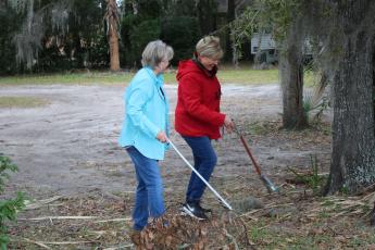 Garden Club members Carol Stevens and Tina Roberts pick up litter near McCray Avenue on Saturday during Lake City’s inaugural “Take Pride in Your Community Clean-Up Campaign.” (MICHAEL PHILIPS/Lake City Reporter)