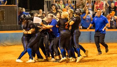 Branford's softball team celebrates with Mallory Blue at home plate after she scored the game-winning run in extra innings to defeat Aucilla Christian in the Region 3-1A semifinals on Thursday. (JACK HOWDESHELL/Special to the Reporter)