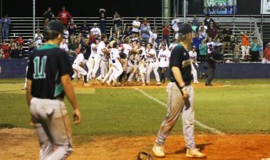 Suwannee’s Logan Brooks and Grayson Greene look on at Wakulla’s celebration at home plate following Hayden Klees’s walk-off home run in the Region 1-4A quarterfinals on Wednesday. (MORGAN MCMULLEN/Lake City Reporter)