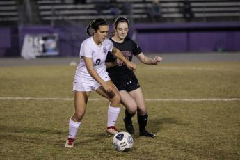 Columbia’s Kirsten Garner fights for possession of the ball with Leon’s Ashley Fink during Monday night’s District 2-6A quarterfinals. (BRENT KUYKENDALL/Lake City Reporter)
