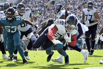 Tennessee Titans running back Derrick Henry dives for a touchdown past Jacksonville Jaguars linebacker Dakota Allen on Oct. 10 in Jacksonville. (PHELAN M. EBENHACK/Associated Press)