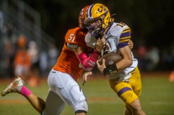 Columbia quarterback Evan Umstead tries to escape a tackle from Orange Park defensive lineman Britton Roberts on Oct. 15. (FRAN RUCHALSKI/Special to the Reporter)
