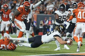Jacksonville Jaguars quarterback Trevor Lawrence (16) dives in for touchdown while being tackled by Cincinnati Bengals' Logan Wilson (55) on Sept. 30 in Cincinnati. (MICHAEL CONROY/Associated Press)