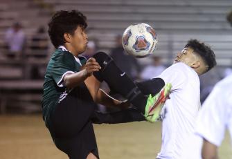 Columbia’s Noel Caballero (right) fights for possession of the ball with a Suwannee player on Tuesday night. (PAUL BUCHANAN/Special to the Reporter)