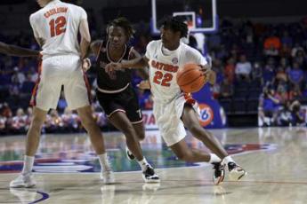 Florida guard Tyree Appleby (22) dribbles around Troy guard Christyon Eugene (5) during Sunday’s game in Gainesville. (MATT STAMEY/Associated Press)
