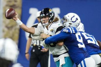 Jacksonville Jaguars quarterback Trevor Lawrence is hit by Indianapolis Colts defensive tackle DeForest Buckner during Sunday’s game in Indianapolis. (AJ MAST/Associated Press)