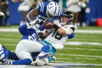 Jacksonville Jaguars quarterback Trevor Lawrence fumbles the ball as he's hit by Indianapolis Colts middle linebacker Bobby Okereke (58) and defensive end Dayo Odeyingbo (54) during Sunday’s game in Indianapolis. (DARRON CUMMINGS/Associated Press)