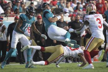 Jacksonville Jaguars quarterback Trevor Lawrence is upended by San Francisco 49ers cornerback Ambry Thomas during Sunday’s game in Jacksonville, Fla. (PHELAN M. EBENHACK/Associated Press)