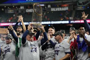 Atlanta Braves manager Brian Snitker holds up the trophy after winning the World Series in Game 6 against the Houston Astros on Tuesday in Houston. The Braves won 7-0. (DAVID J. PHILLIP/Associated Press)