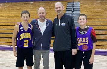 Columbia head coach Steve Faulkner (second from right) and his two sons, Jordan (left) and Tyler (right) are pictured with Ernie Johnson on Wednesday. Johnson made a surprise visit to the school after hearing of Faulkner’s battle with throat cancer. (COURTESY)