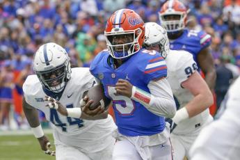Florida quarterback Emory Jones scores a touchdown on a 31-yard run as he gets past Samford defender Tay Berry, left, and defensive tackle Seth Simmer on Saturday in Gainesville. (JOHN RAOUX/Associated Press)