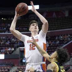 Florida forward Colin Castleton shoots over South Florida guard Caleb Murphy during the Orange Bowl Basketball Classic on Saturday in Sunrise. (LYNNE SLADKY/Associated Press)