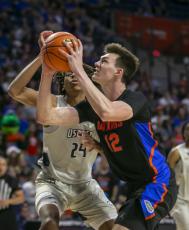 Florida forward Colin Castleton drives on North Florida forward Jadyn Parker during Wednesday's game in Gainesville. (ALAN YOUNGBLOOD/Associated Press)