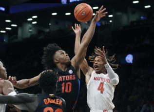 Maryland's Fatts Russell has the ball knocked away by Florida's Elijah Kennedy during Sunday's game in New York. (JASON DECROW/Associated Press)