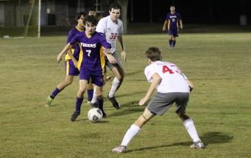 Columbia’s Wesley Wingate dribbles up the field as Santa Fe’s Ethan Barnes chases after him on Friday night. (JORDAN KROEGER/Lake City Reporter)
