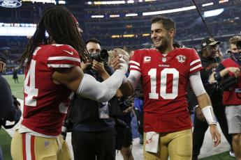 San Francisco 49ers middle linebacker Fred Warner, left, celebrates with quarterback Jimmy Garoppolo (10) after the 49ers defeated the Dallas Cowboys in a wild-card playoff game on Sunday in Arlington, Texas. (ROGER STEINMAN/Associated Press)