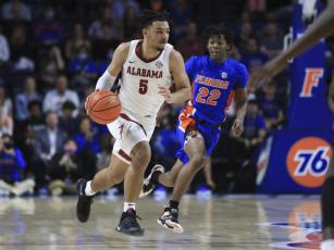 Alabama guard Jaden Shackelford (5) brings the ball up past Florida guard Tyree Appleby (22) during the first half of an NCAA college basketball game Wednesday, Jan. 5, 2022, in Gainesville. (MATT STAMEY/Associated Press)