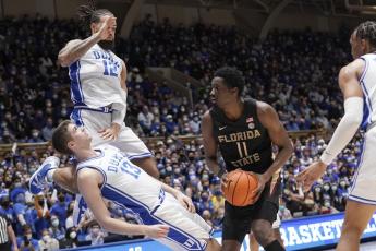 Duke forward Joey Baker (13) draws a charge against Florida State center Tanor Ngom (11) while Duke forward Theo John (12) defends during Saturday’s game in Durham, N.C. (GERRY BROOME/Associated Press)