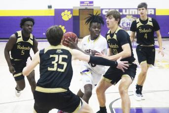 Columbia guard Isaac Broxey drives to the basket as Buchholz forwards Anthony Wilkie (20) and Palmer Walton (35) defend during Tuesday’s District 3-6A quarterfinal. (JORDAN KROEGER/Lake City Reporter)