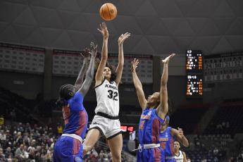 Central Florida's Brittney Smith, center, shoots between Florida's Faith Dut, left, and Florida's Zippy Broughton, right, during their first-round game in the NCAA tournament on Saturday Storrs, Conn. (JESSICA HILL/Associated Press)