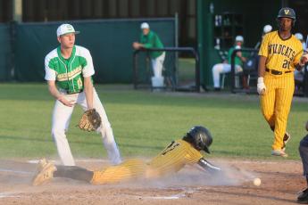 The ball gets away from Suwannee’s Ethan Layton as Valdosta’s Sam Houston slides safely into home plate during Tuesday’s game. (PAUL BUCHANAN/Special to the Reporter)