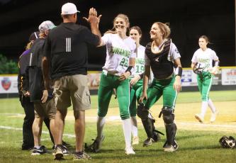 Suwannee pitcher Karis Smith (middle) high-fives coaches and teammates as she walks off the field following her perfect game against Columbia on Friday night. (PAUL BUCHANAN/Special to the Reporter)