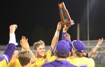 Columbia’s Brent Howard raises the District 3-5A trophy after the Tigers defeated St. Augustine 11-2 on Thursday. (JORDAN KROEGER/Lake City Reporter)