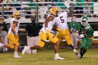 Columbia safety Amare Ferrell returns an interception 97 yards for a touchdown while Suwannee running back Marquavious Owens gives chase on Friday night in the Preseason Classic at Langford Stadium. (BRENT KUYKENDALL/Lake City Reporter)