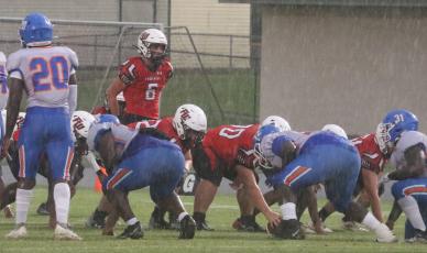 Fort White quarterback Clayton Philpot gets set for the snap in a driving rainstorm during Friday’s game against Taylor County. (MORGAN MCMULLEN/Lake City Reporter)