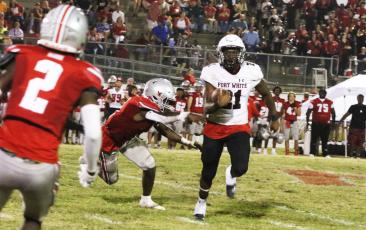 Fort White running back Kamarion Griffin tries to avoid a Williston defender Friday night. (MORGAN MCMULLEN/Lake City Reporter)