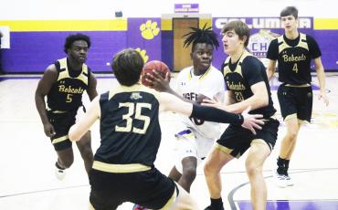 Columbia guard Isaac Broxey drives to the basket as Buchholz forwards Anthony Wilkie (20) and Palmer Walton (35) defend during the District 3-6A quarterfinals on Feb. 8. (FILE)