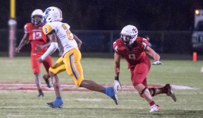 Fort White defensive end Avery Giddens heads in to tackle to Newberry running back Kaleb Woods on Friday night. (CHRISTINA FEAGIN/Special to the Reporter)