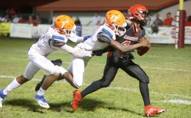 Branford safety Zjhamaria Wilson (13) tackles Lafayette running back Johntavious Cook with defensive back Arkayvion Jones behind him in pursuit on Oct. 17. (PAUL BUCHANAN/Special to the Reporter)