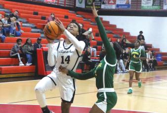 Fort White forward Isreal Hart goes up for a shot against Suwannee guard Janeah Mitchell on Monday night. (MORGAN MCMULLEN/Lake City Reporter)