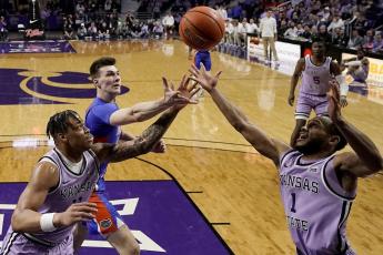 Kansas State forward Keyontae Johnson, left, and guard Markquis Nowell (1) compete for a rebound with Florida forward Colin Castleton during the Saturday’s game in Manhattan, Kan. (CHARLIE RIEDEL/Associated Press)