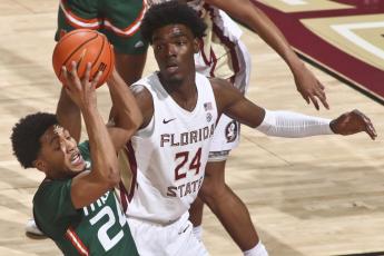 Miami guard Nijel Pack (24) gets a rebound as Florida State center Naheem McLeod (24) looks on during Tuesday's game in Tallahassee. (PHIL SEARS/Associated Press)