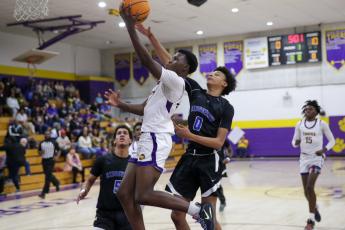 Columbia guard Isaac Broxey drives past Ridgeview’s Calen Wiggins for a layup Wednesday night in a District 2-5A tournament semifinal. (BRENT KUYKENDALL/Lake City Reporter)