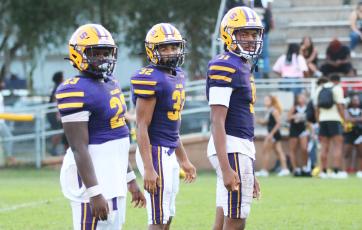 Columbia running back Jonathan Andrews (from left), running back TC Smith and quarterback Zack Paulk wait for a play call during Saturday's game against Buchholz. (JORDAN KROEGER/Lake City Reporter)