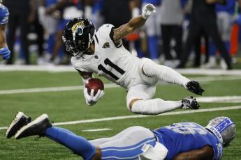 Jacksonville Jaguars wide receiver Parker Washington falls over Detroit Lions defensive end Isaiah Buggs during Saturday's preseason game in Detroit. (DUANE BURLESON/Associated Press)