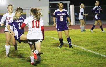 Columbia's Mia Brasel dribbles between Santa Fe defenders on Thursday night. (JORDAN KROEGER/Lake City Reporter)
