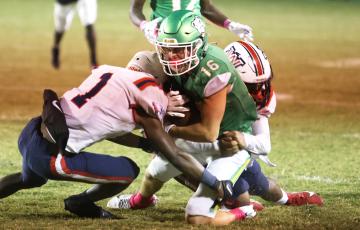 Suwannee receiver Noah Lopez is tackled by a pair of Wakulla defenders during last season’s meeting. Suwannee and Wakulla will be in the same district again next season. (PAUL BUCHANAN/Special to the Reporter)