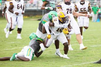 Columbia receiver Zamarion Jones tries to escape a tackle from Suwannee linebacker Lan’darren Gross during last season’s Preseason Classic. The teams will meet in the season opener this year on Aug. 23. (BRENT KUYKENDALL/Lake City Reporter)