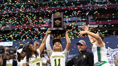 FGC’s Makenzie Phillian lifts the NJCAA championship trophy alongside Klaudia Taylor (7) and head coach Ricky Hufty after the Timberwolves won the inaugural NJCAA title on Saturday at Mercedes-Benz Stadium in Atlanta. (COURTESY OF NFL FLAG)