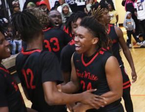 Fort White guard Darion Brinson celebrates with teammates after Fort White knocked off top-seeded Hawthorne 56-51 in the Region 3-1A semifinals on Thursday. (MORGAN MCMULLEN/Lake City Reporter)