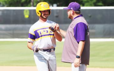 Columbia first baseman Philip Maddox fist bumps assistant coach Joey Edge after hitting an RBI single during Tuesday’s win over The Villages Charter. (JORDAN KROEGER/Lake City Reporter)