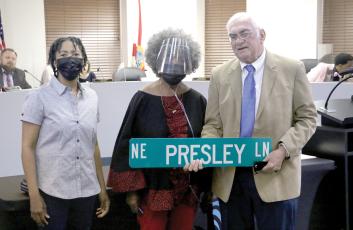 Lake City Mayor Stephen Witt holds up the NE Presley Lane sign next to Bernice Presley (middle) and Sharyn Presley (left) after the Lake City Council agreed to rename NE Railroad Street in honor of the Presley family. (MORGAN MCMULLEN/Lake City Reporter)