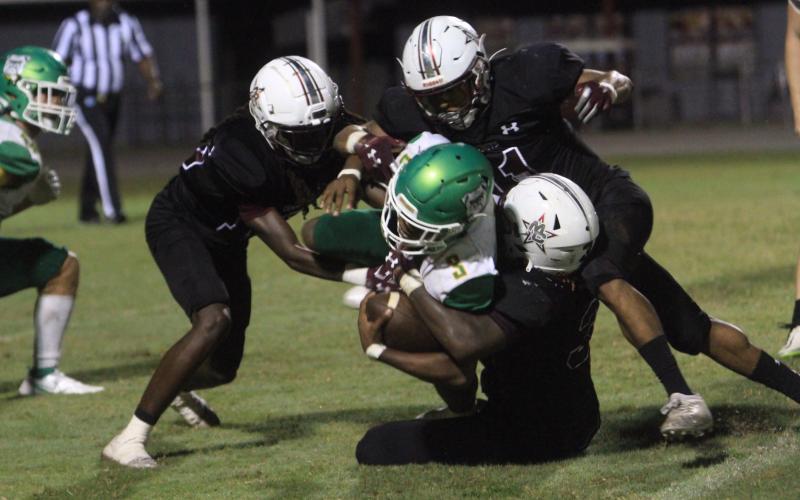 Suwannee running back Malachi Graham is tackled by a host of Madison County defenders on Friday. (PAUL BUCHANAN/Special to Reporter)