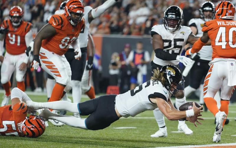 Jacksonville Jaguars quarterback Trevor Lawrence (16) dives in for touchdown while being tackled by Cincinnati Bengals' Logan Wilson (55) on Sept. 30 in Cincinnati. (MICHAEL CONROY/Associated Press)