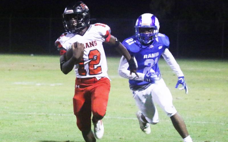 Fort White receiver Najeeb Smith rushes up the field past Interlachen defensive back Jamarion Esau on Friday. (MORGAN MCMULLEN/Lake City Reporter)