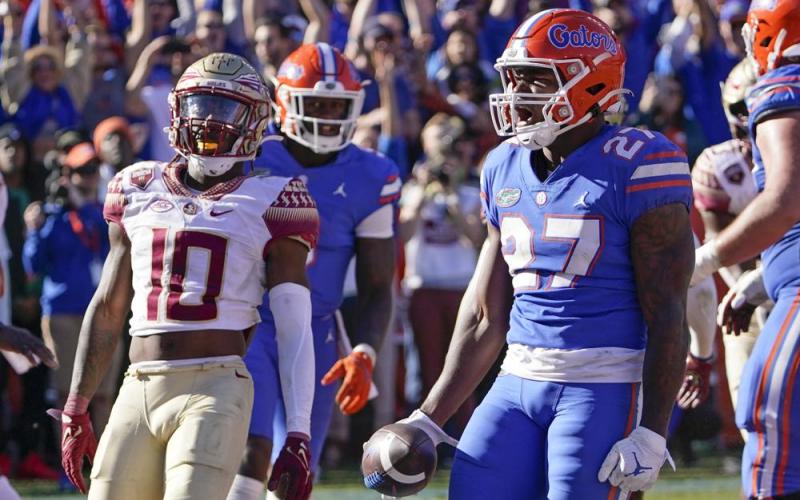 Florida running back Dameon Pierce (27) celebrates a 3-yard touchdown run as Florida State defensive back Jammie Robinson (10) looks on during Saturday's game in Gainesville. (JOHN RAOUX/Associated Press)